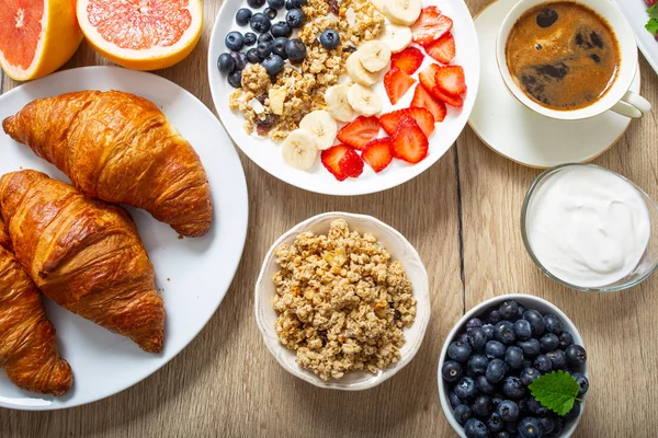 Desayuno saludable servido con un plato de yogur muesli arándanos fresas y plátano . — Foto de Stock