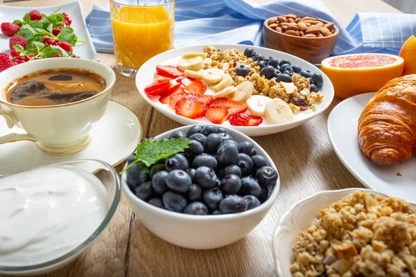 Hälsosam frukost serveras med tallrik yoghurt müsli blåbär jordgubbar och banan. — Stockfoto