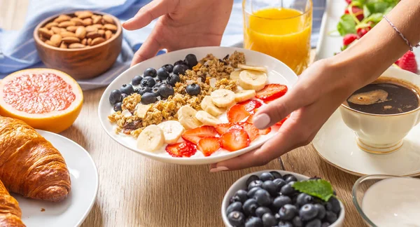 Desayuno saludable servido con un plato de yogur muesli arándanos fresas y plátano . — Foto de Stock