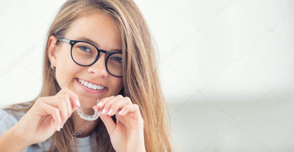 Dental invisible braces or silicone trainer in the hands of a yo
