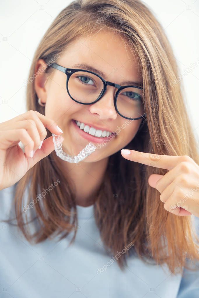 Dental invisible braces or silicone trainer in the hands of a yo