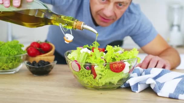 Hombre Cocina Vertiendo Aceite Oliva Ensalada Verduras Frescas Cocina Vídeo — Vídeo de stock