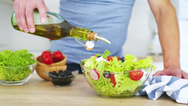 Hombre Cocina Vertiendo Aceite Oliva Ensalada Verduras Frescas Cocina Vídeo — Vídeo de stock