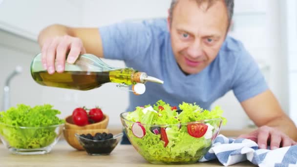 Hombre Cocina Vertiendo Aceite Oliva Ensalada Verduras Frescas Cocina Vídeo — Vídeo de stock