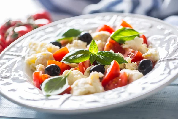 Σαλάτα Caprese με μοτσαρέλα, φρέσκες ντομάτες, ελιές και φύλλα βασιλικού. Ιταλικό ή μεσογειακό υγιεινό γεύμα — Φωτογραφία Αρχείου