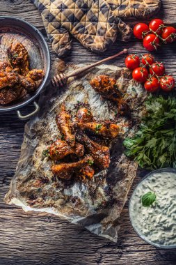 Kızarmış tavuk budu ızgara kağıtta tzatziki soslu domates ve maydanozlu otlar..