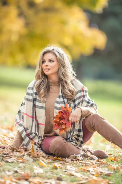 Atractiva joven con sonrisa sensual sentada en el parque de otoño —  Fotos de Stock