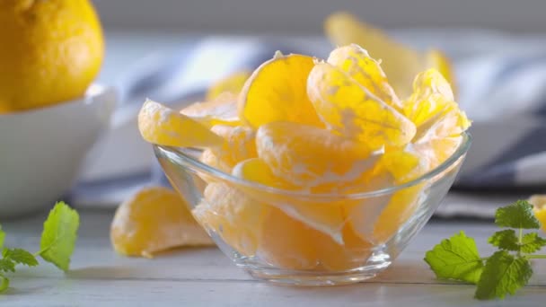 Mandarinas Frescas Maduras Tazón Vidrio Con Hierbas Melisa Sobre Mesa — Vídeos de Stock