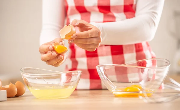 Detail of womans hands separating egg yolks from the whites into two glass bowls — Stock Photo, Image