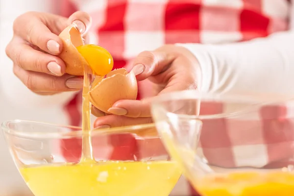 A tojássárgáját a fehérektől két üvegtálba elválasztó női kezek részletei — Stock Fotó