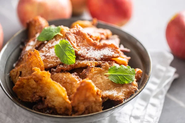 Fijngebakken appelpannenkoeken bestrooid met vanillesuiker en kaneel bedekt met muntblaadjes — Stockfoto