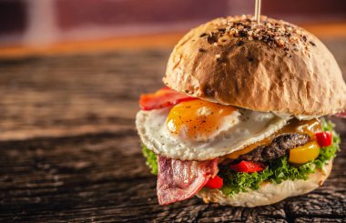 Köy ortamında sığır eti, peynir, yumurta, pastırma, salata ve biberli hamburgerin ayrıntıları