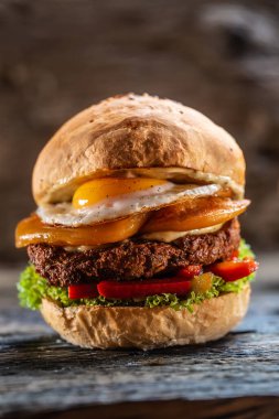 Çift peynirli vejetaryen fasulye burger, kızarmış yumurta, biber ve salata.