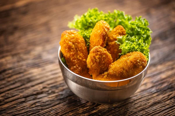 Chicken nuggets with salad in a metal bowl on a rustic wooden surface — Stock Photo, Image