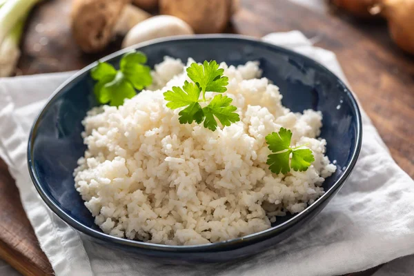 Schaal gestoomde rijst met champignons en lekken op de achtergrond — Stockfoto