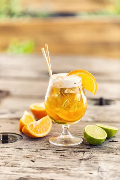 Beer lemonade in a glass with freshly cut orange, ice and paper straws
