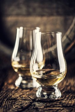İki Glencairn viski tadım bardağı eski ahşap ve arkada koyu ahşap fıçı
