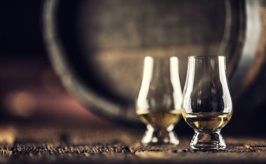 İki Glencairn viski tadım bardağı eski ahşap ve arkada koyu ahşap fıçı