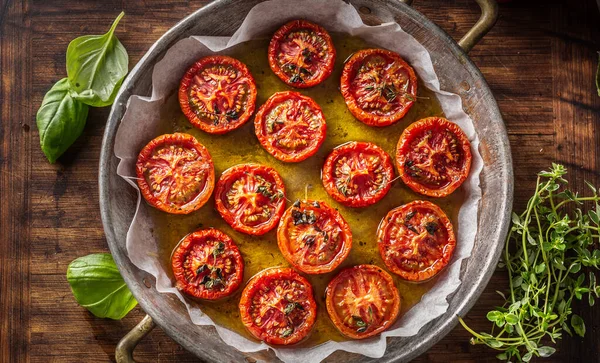 Geroosterde tomaten met olijfolie tijm oregano en basilicum in pan — Stockfoto