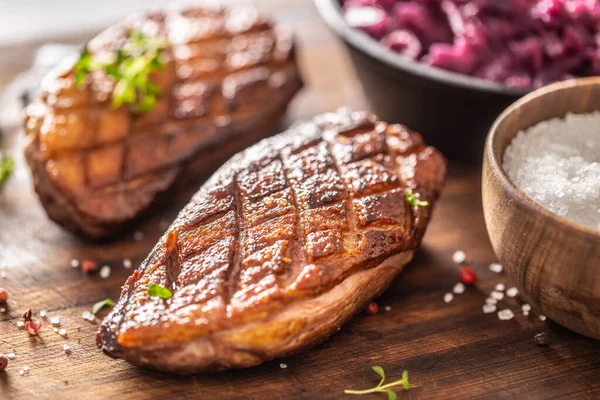 Dettaglio di gustosi petti di anatra arrosto e cavolo rosso stufato su un tagliere di legno — Foto Stock