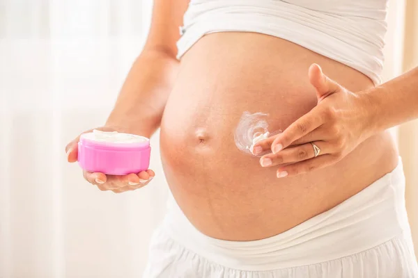 Zwangere Vrouw Buik Detail Een Hand Met Een Vochtinbrengende Crème — Stockfoto