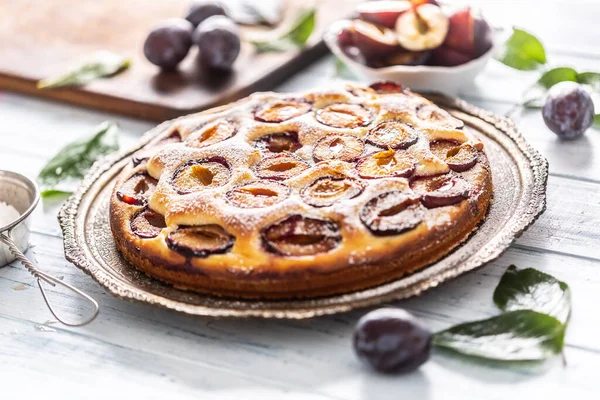 Homemade plum cake in vintage plate on wooden table. Plums pie with sugar powder — Stock Photo, Image