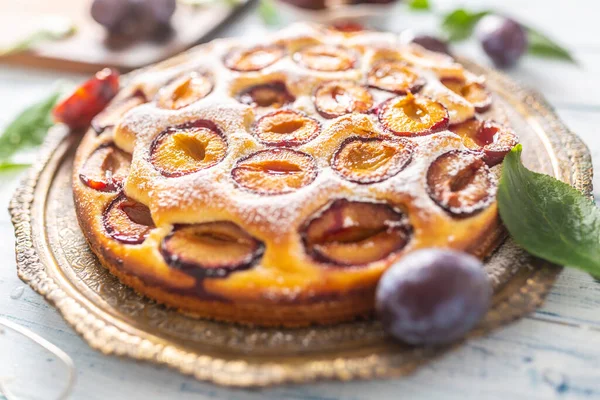 Homemade plum cake in vintage plate on wooden table. Plums pie with sugar powder — Stock Photo, Image