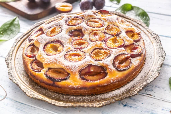 Homemade plum cake in vintage plate on wooden table. Plums pie with sugar powder — Stock Photo, Image
