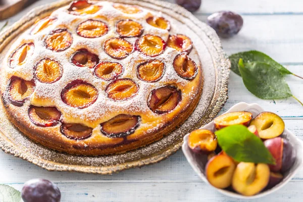 Homemade plum cake in vintage plate on wooden table. Plums pie with sugar powder — Stock Photo, Image