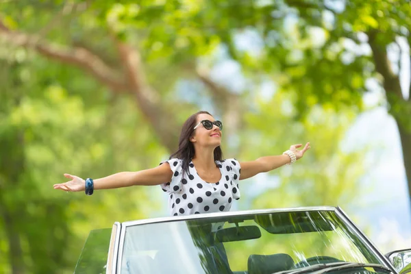 Frau Mit Sonnenbrille Sitzt Mit Weit Aufgerissenen Armen Auf Dem — Stockfoto