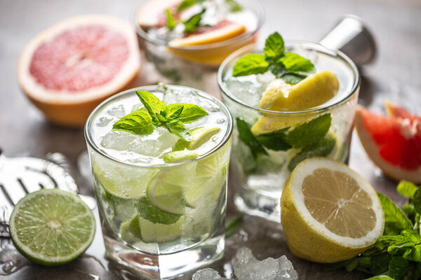 Three colorful gin tonic cocktails in whiskey glasses on bar counter in pup or restaurant