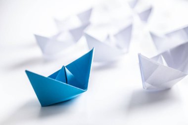 Mavi ve beyaz kağıt tekneler. Takım çalışması için liderlik gemisi kavramı veya başarı.