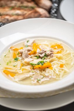 Erişteli tavuk çorbası, havuç ve taze maydanoz..