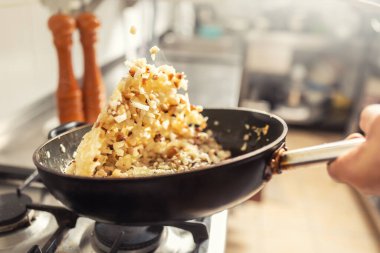 Soğan ve pastırma mutfağın içinde bir tavaya atılmış. Khichri tavaya atılmış..