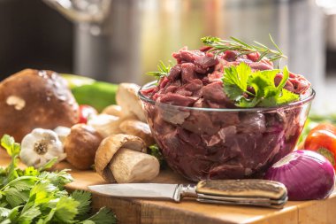 Dilimlenmiş geyik eti. Orman güveci için. Mantar, sebze ve bıçak..