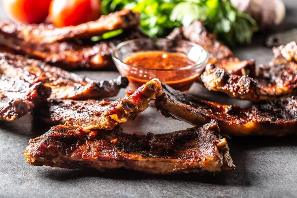 Baked glazed bbq ribs with a chilli sauce on the side.