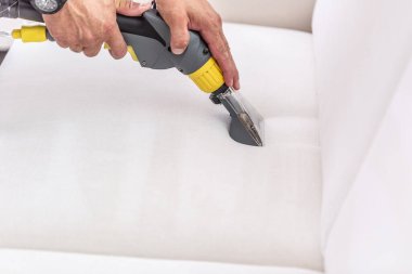 Ayrıntılı olarak beyaz bir kanepenin şampuan temizliği.