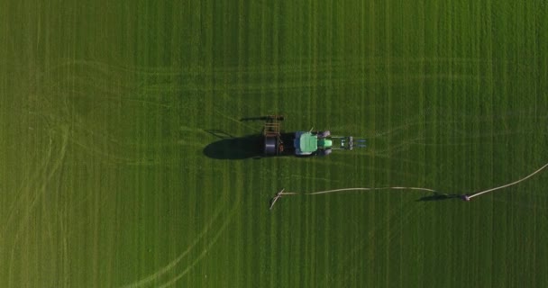 Nad hlavou shora dolů letecký pohled na traktoru v poli. Muž pracuje v blízkosti traktoru — Stock video