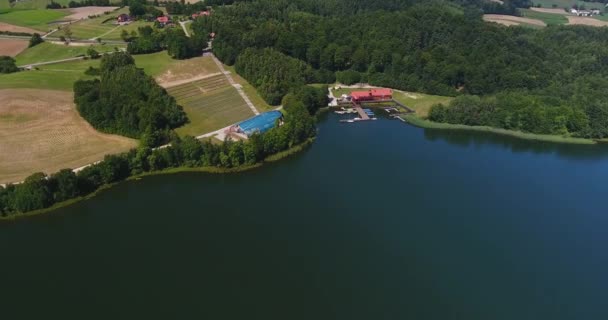 Vista aérea do lago azul e da casa na floresta — Vídeo de Stock