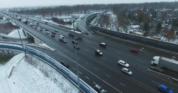 Los coches fluyen en la autopista en invierno. Escena aérea. Inclinación lenta hacia abajo — Vídeos de Stock