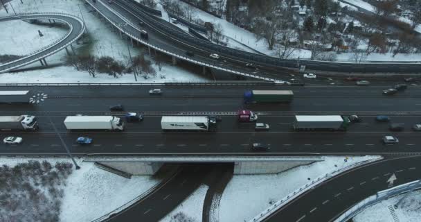 Caudal de tráfico lento en la intersección de carreteras en invierno. Vista lateral aérea — Vídeos de Stock