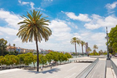 Park yakınlarında nehir Guadalquivir ve Triana bölge Golden Tower (Torre del Oro) mavi gökyüzü ve beyaz bulutlar güzel manzara artalan üzerinde. Yaz seyahat 