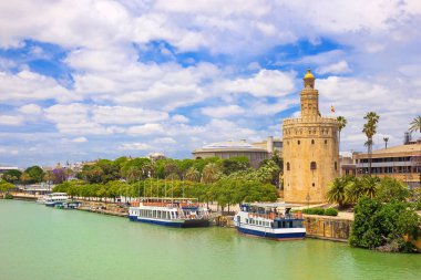 Guadalquivir nehrinden Altın Kule Torre del oro için güneşli yaz gün, mavi gökyüzü ve beyaz bulutlar, görüntüleyin