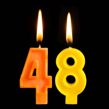 Yanan Doğum günü mumları siyah arka plan üzerine izole kek için 48 kırk sekiz şeklinde.