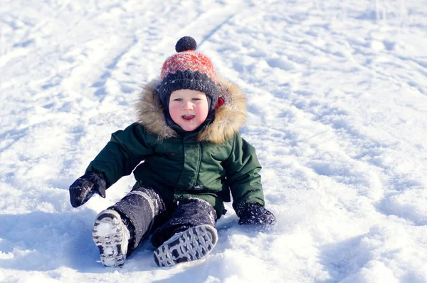 Fröhlicher Junge auf einem schneebedeckten Berg im Winter Stockbild