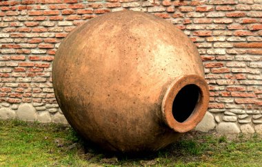 Qvevri sürahi için şarap yapma üzerinde tuğla duvar arka plan. Bir amfora gibi.