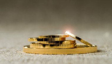 Tarafsız bir arka plan bulanık üzerinde irili ufaklı altın sikke yığını.