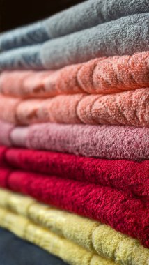 Bir yığın çeşitli terry havlu üzerinde karanlık bir arka plan renkleri. Seçici odak.