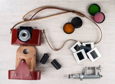 Bir deri çanta, kaset, renk filtreleri, slaytlar Vintage fotoğraf makinesi ve bir mini masa yüzeyine stand.