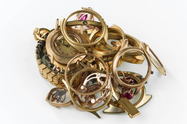 Bir hurda altın. Eski ve kırık mücevher, altın ve beyaz zemin üzerine altın kaplama saatler.